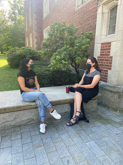 student and professor sitting outside